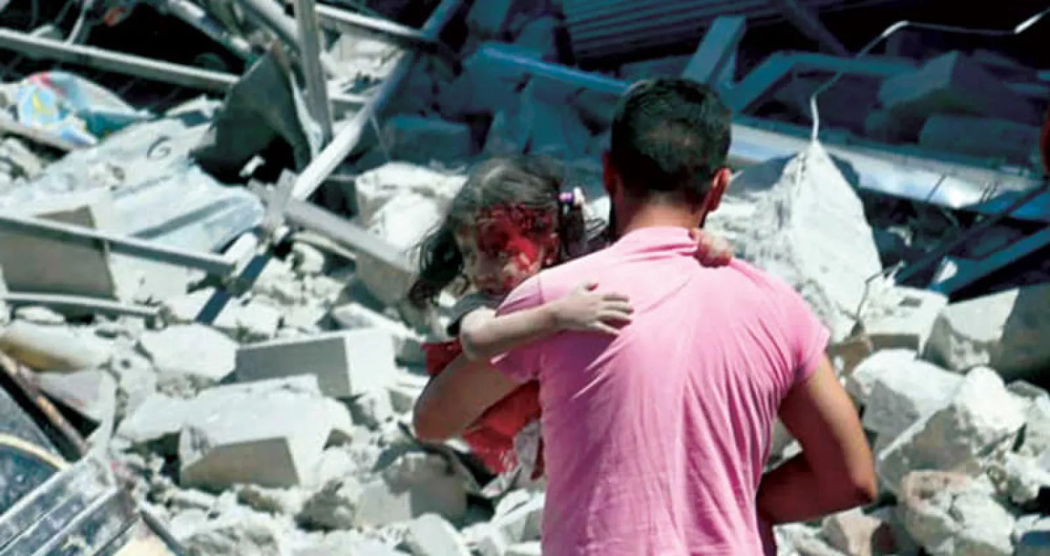 يسعف طفلة أصيبت بقصف على أريحا في ريف أدلب أمس (أب)