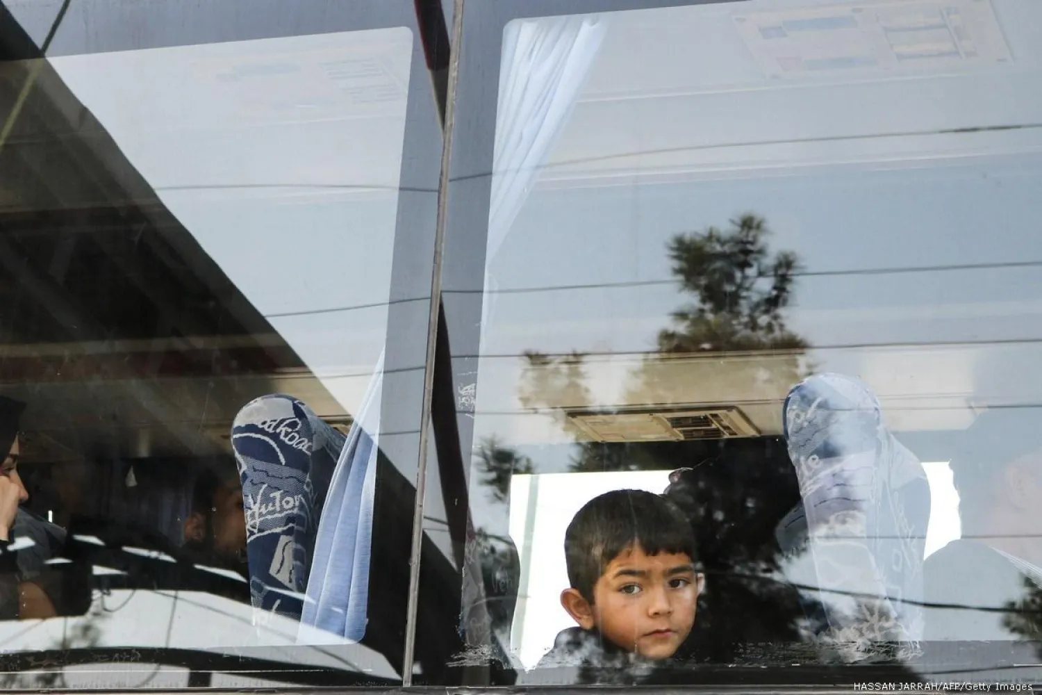  Syrian refugees evacuated from the southern Lebanese village of Shebaa ride a bus through the Masnaa crossing on the Lebanon-Syria border leading to Damascus on 18 April 2018 [HASSAN JARRAH/AFP]