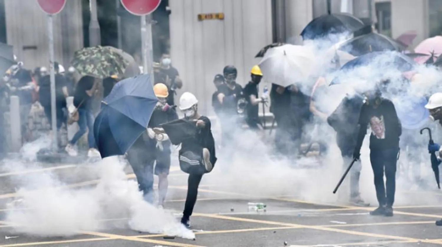 Çevik kuvvet polisleri Çin sınırına yakın Yuen Long bölgesinde protestoculara göz yaşartıcı bomba attı (AFP)