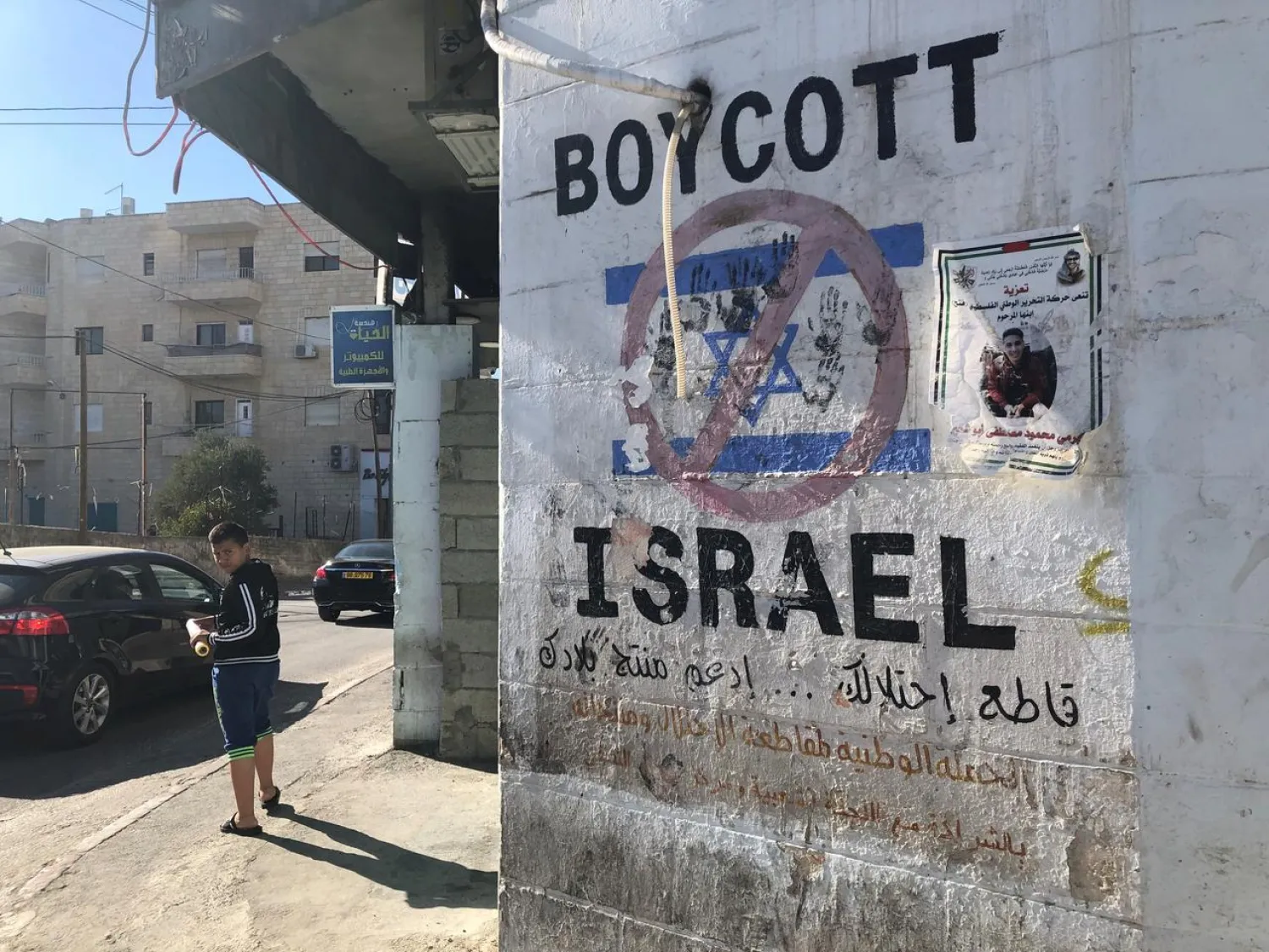 A Palestinian boy near a graffiti boycotting Israel in Bethlehem, in occupied West Bank (File Photo: Reuters)