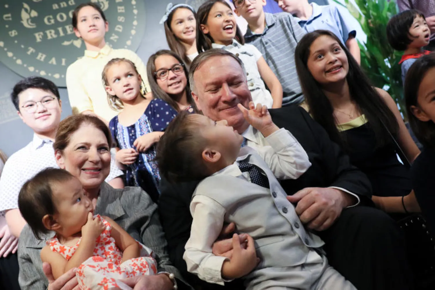 وزير الخارجية الأميركي مايك بومبيو وزوجته مع أفراد طاقم السفارة الأميركية في بانكوك وأولادهم (رويترز)