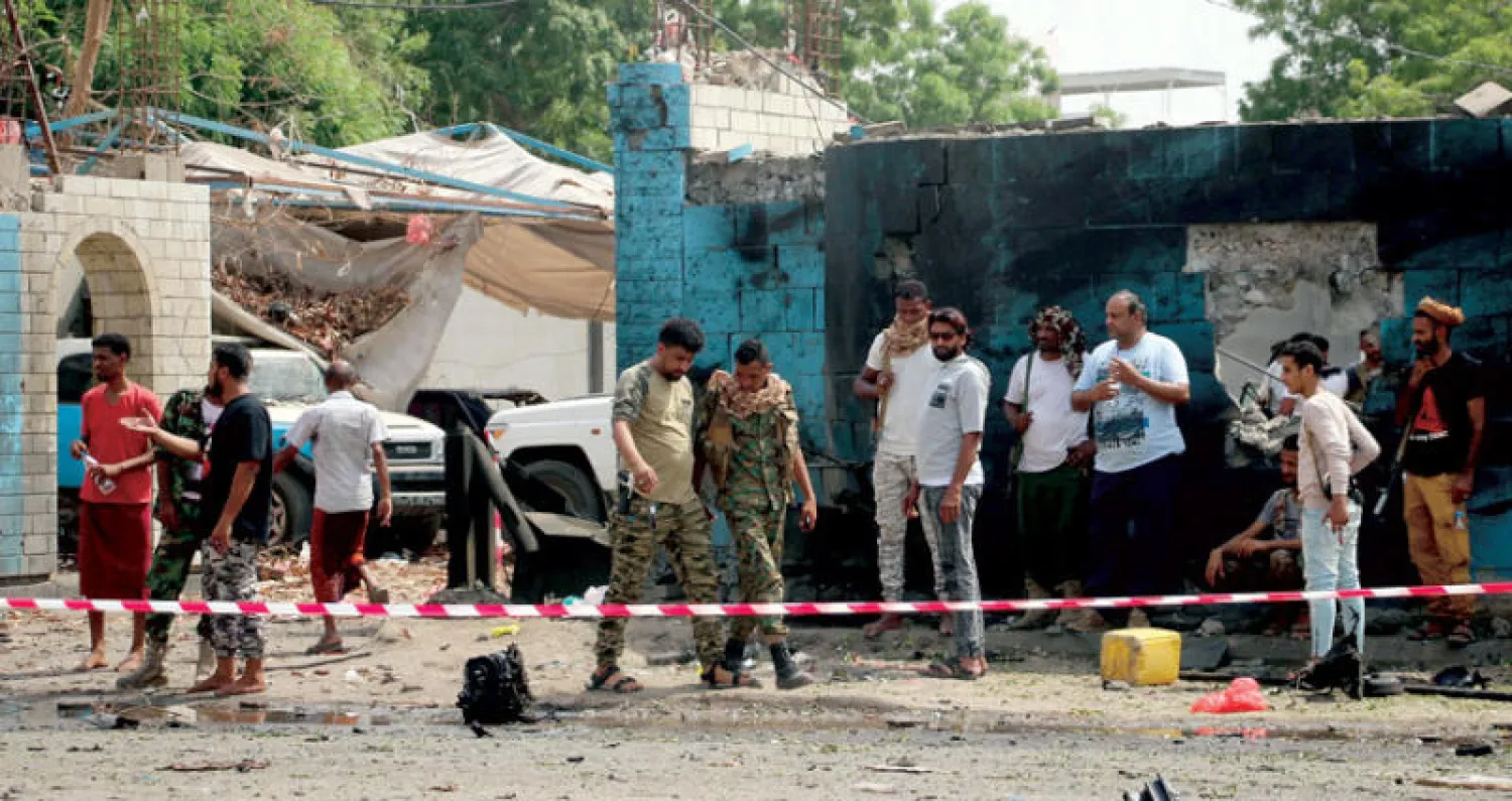 يمنيون يتفحصون بقايا التفجير الإرهابي الذي تبناه تنظيم «داعش» في عدن الخميس (إ.ب.أ)