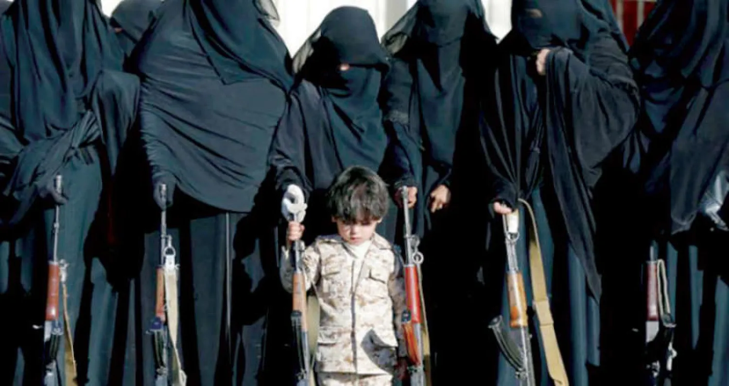 طفل مع نساء في تجمع مسلح بصنعاء (رويترز)