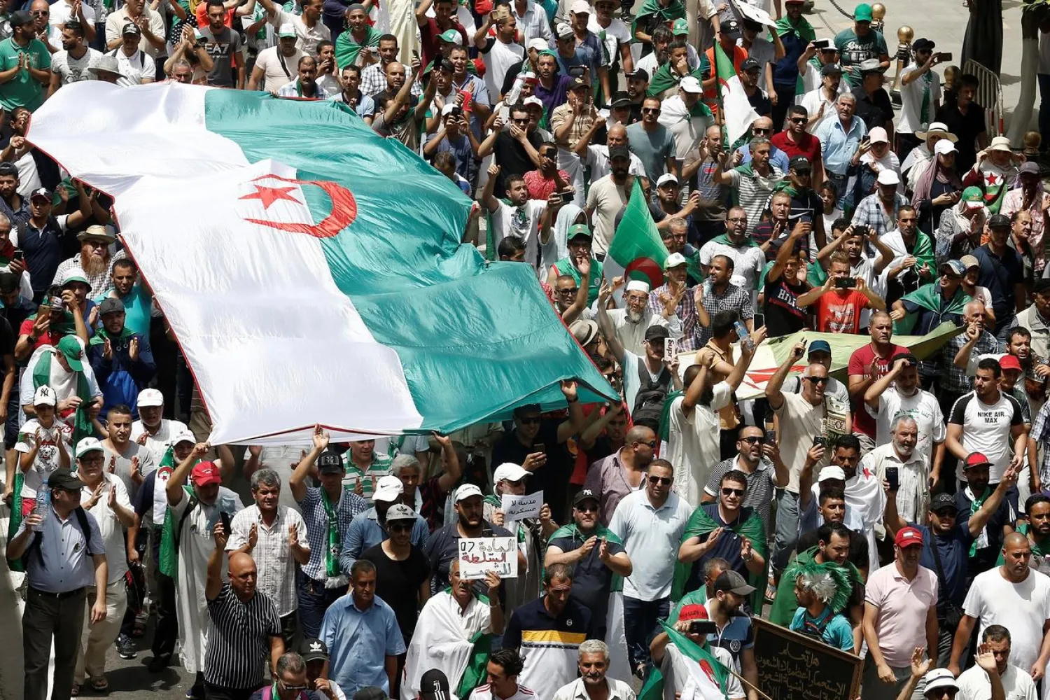  Demonstrators carry banners and flags during a protest demanding the removal of the ruling elite in Algiers, Algeria July 5, 2019, the day marking the country's independence day. Reuters/Ramzi Boudina
