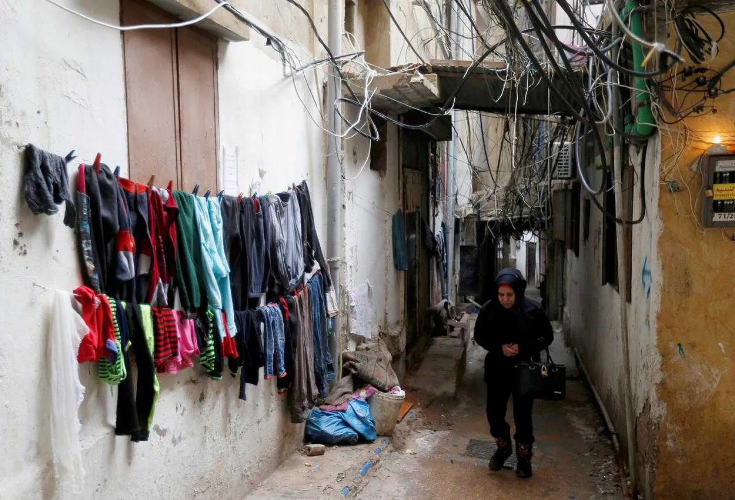 A woman walks past clothes left to dry in Burj al-Barajneh refugee camp in Beirut, Lebanon, January 29, 2018. Picture taken January 29, 2018. REUTERS/Mohamed Azakir
