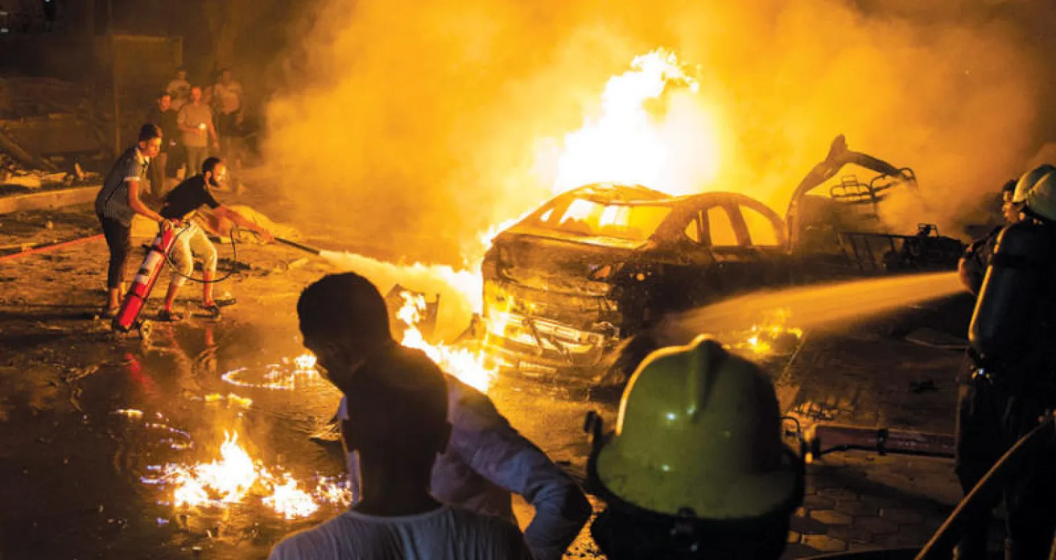 اطفاء حريق بعد انفجار سيارة مفخخة أمام مستشفى معهد علاج أورام السرطان في القاهرة ليل الاثنين (إ.ب.أ)