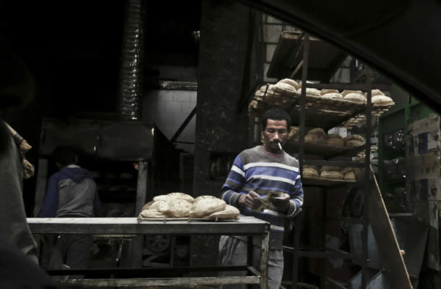  In this Tuesday, Feb. 14, 2017, file, photo, a vendor counts his money at a bread stand in the Sayeda Zeinab neighborhood of Cairo, Egypt. AP