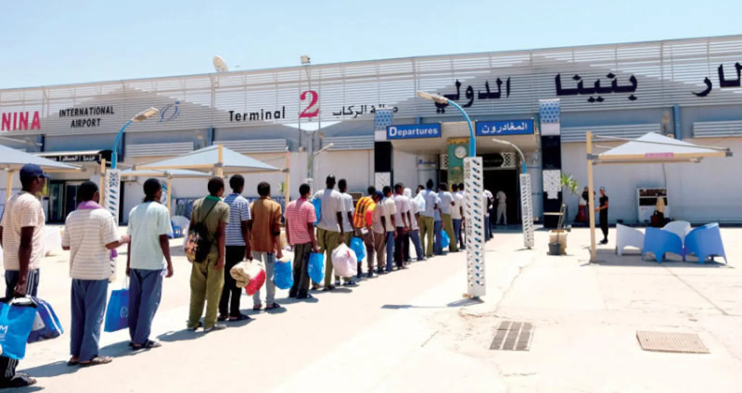 مهاجرون غير شرعيين من السودان ينتظرون ترحيلهم إلى بلادهم عند مدخل مطار بنينا في بنغازي أمس (رويترز)