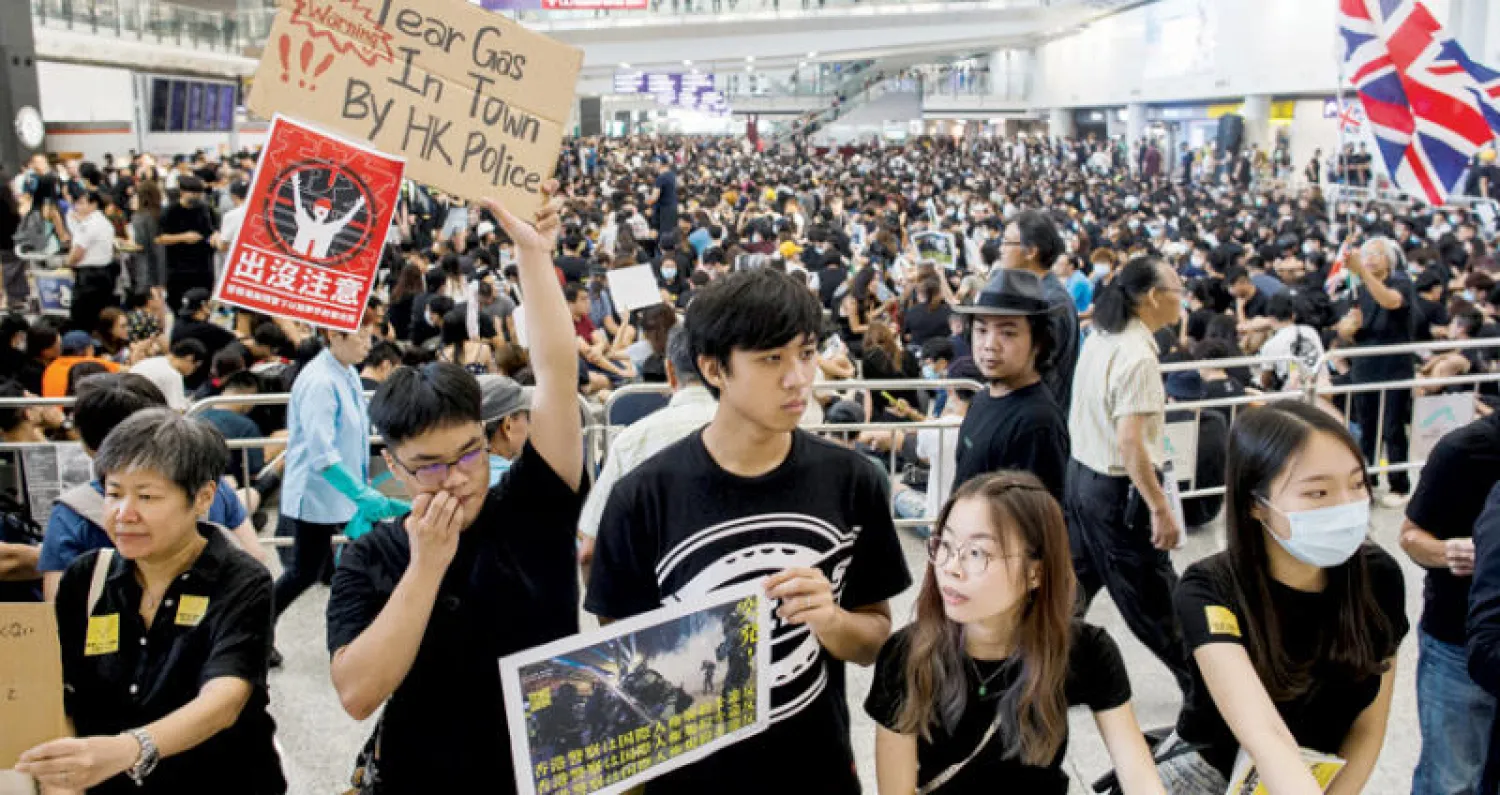 بدأ مئات المتظاهرين الداعمين للديمقراطية اعتصاماً الجمعة في مطار هونغ كونغ للفت أنظار الزائرين الأجانب إلى تحركهم الذي بدأ قبل شهرين (رويترز)