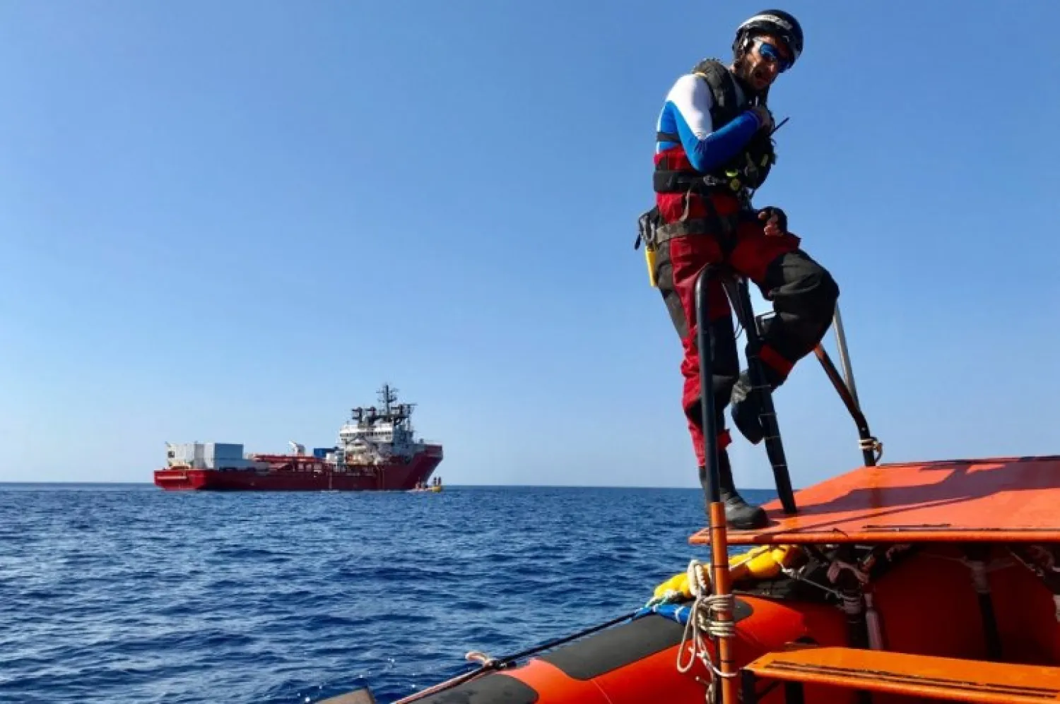 A member of the French NGOs SOS Mediterranee and Medecins sans Frontieres (MSF) new boat Ocean Viking takes part in a team exercise to get ready for a rescue situation at sea with an inflatable dinghy, on their way to the coasts of Libya, on August 5, 2019. / AFP / Anne CHAON