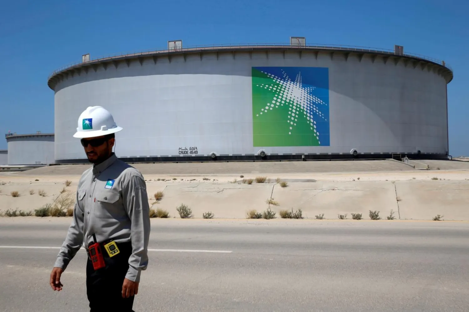 Suudi Arabistan'ın Ras Tanura rafinerisindeki petrol tankının yakınındaki bir Aramco işçisi (Reuters)