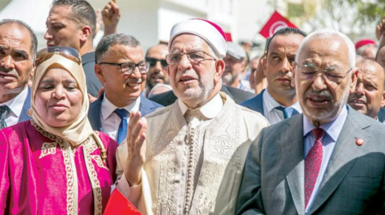 عبد الفتاح مورو خلال تقديم ملف ترشحه لرئاسية تونس وإلى جانبه راشد الغنوشي (أ.ب)