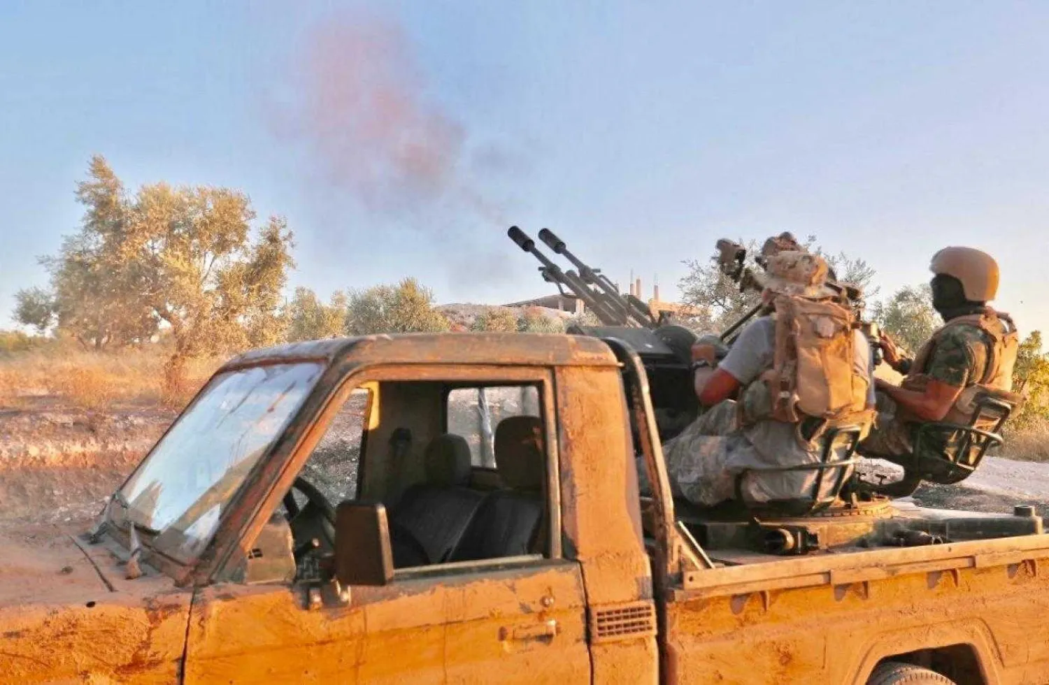 Fighters from Hayat Tahrir al-Sham fire anti-aircraft gun mounted on pickup truck in Syria's southern Idlib province. AFP file photo