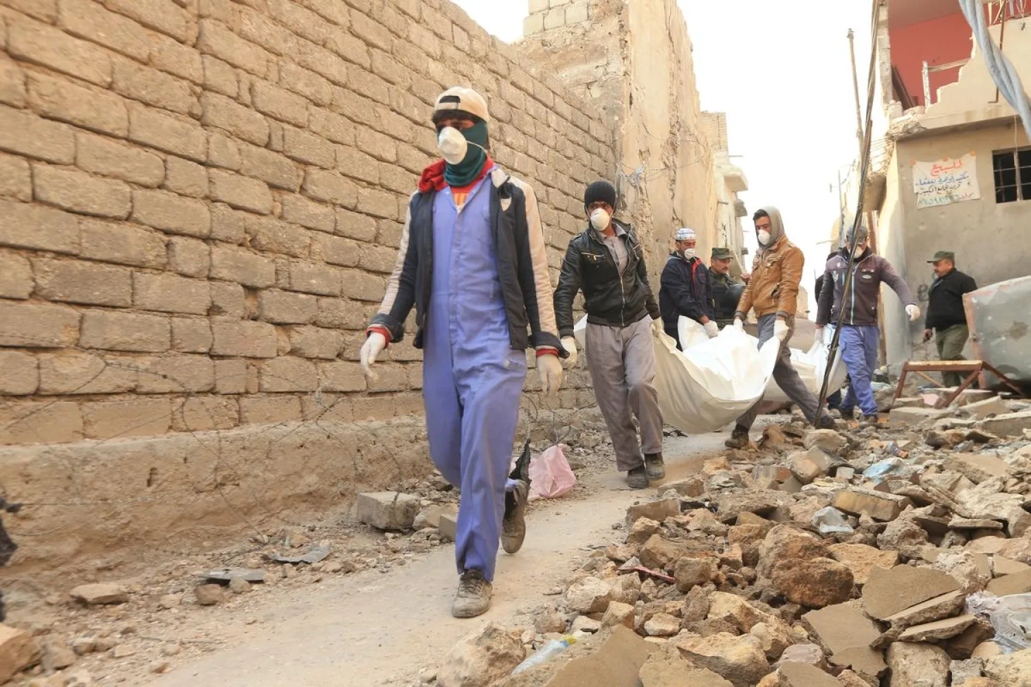 Local residents carry bodies taken from the rubble in the Old City of Mosul, Iraq January 17, 2018. REUTERS/Ari Jalal
