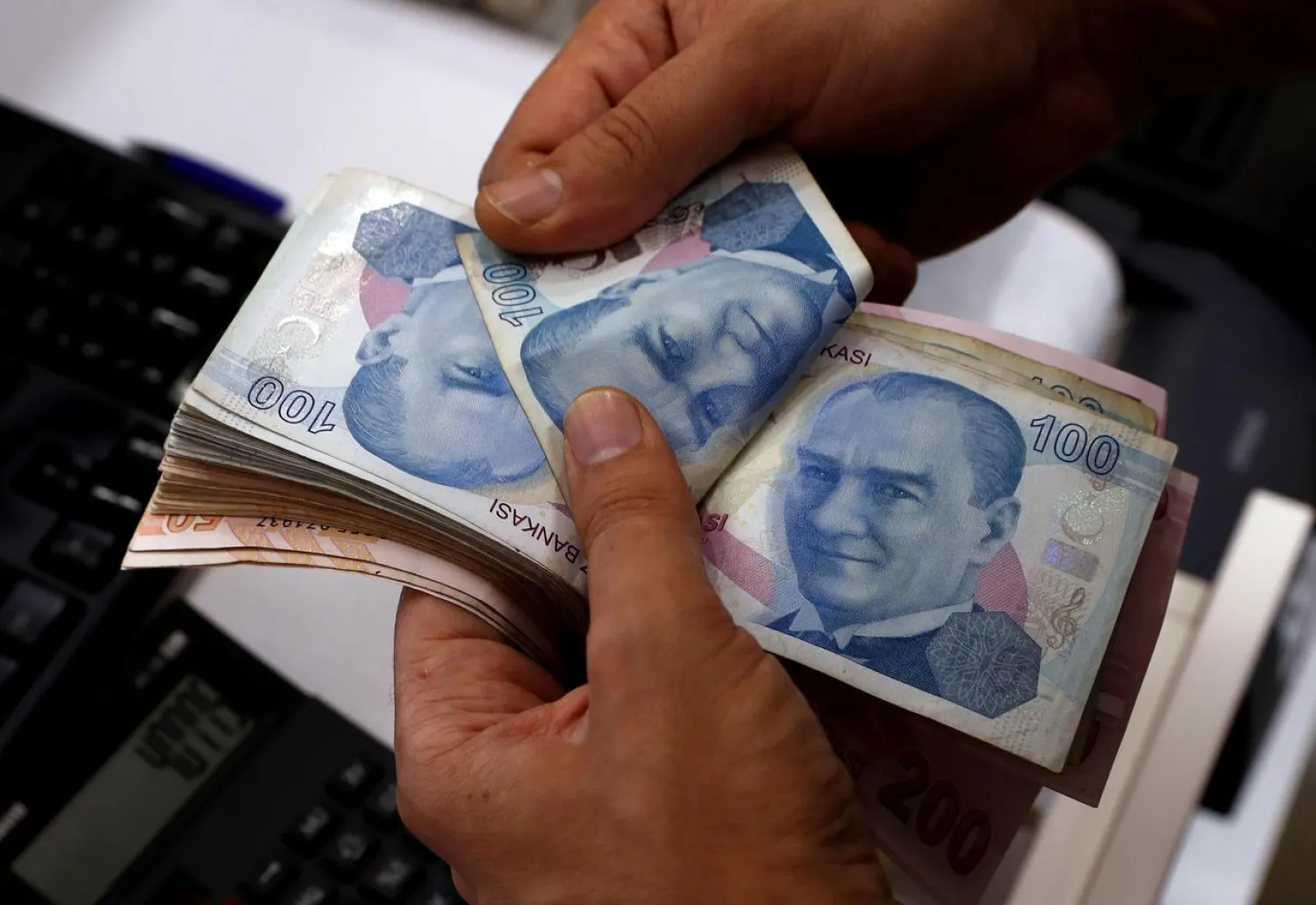 FILE PHOTO: A money changer counts Turkish lira banknotes at a currency exchange office in Istanbul, Turkey August 2, 2018. REUTERS/Murad Sezer//File Photo