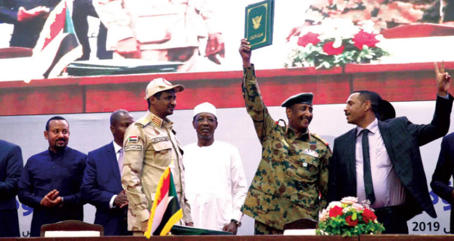 رئيس المجلس العسكري الانتقالي عبد الفتاح البرهان وعضو «قوى إعلان الحرية والتغيير» أحمد ربيع وبدا نائب رئيس «العسكري» محمد حمدان دقلو «حميدتي» بعد توقيع «الوثيقة الدستورية» في مراسم خاصة بالخرطوم أمس وسط حضور عربي ودولي (أ.ف.ب)