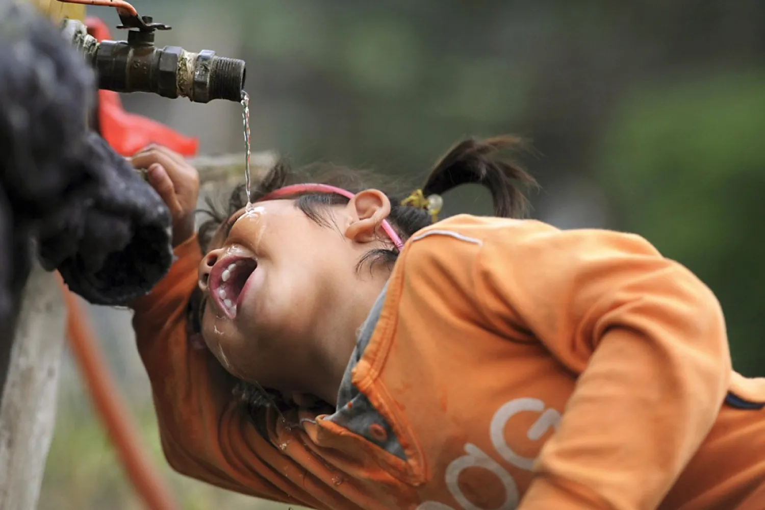 A girl drinks from a tap in Anhui. Photo: Reuters
