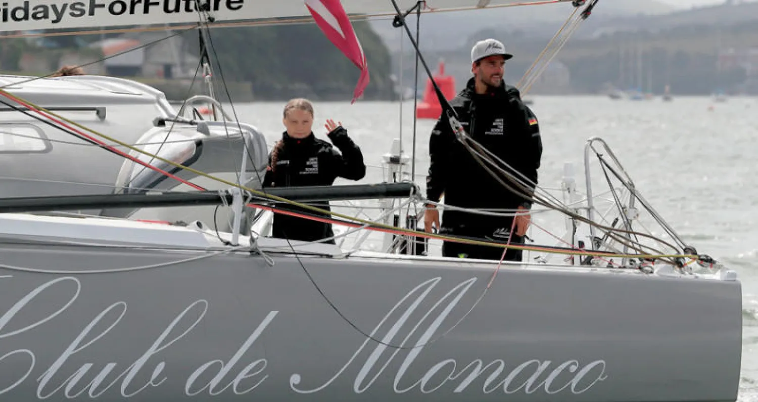 غريتا ثنبرغ الفتاة السويدية الناشطة في المجال البيئي مع القبطان الألماني بوريس هيرمان أثناء استعدادها للإبحار يوم الأربعاء الماضي عبر المحيط الأطلسي بدلاً من السفر جواً (أ.ف.ب)