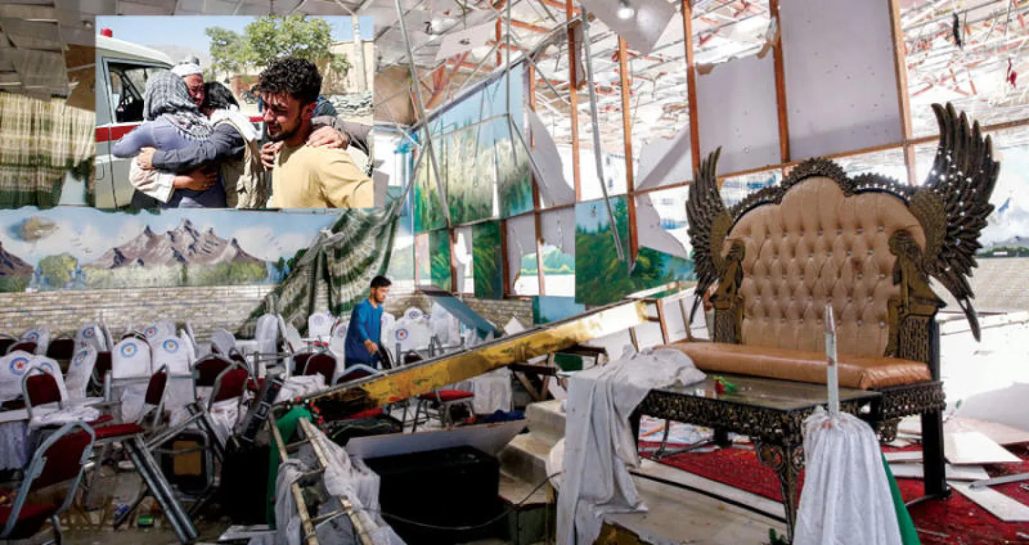 جانب من الدمار في قاعة عرس بكابل استهدفه هجوم انتحاري مساء أول من أمس تبناه تنظيم «داعش» أمس  أوقع 63 قتيلاً و182 جريحاً (إ.ب.أ)... وفي الإطار أقارب ضحايا يواسي بعضهم بعضاً (رويترز)