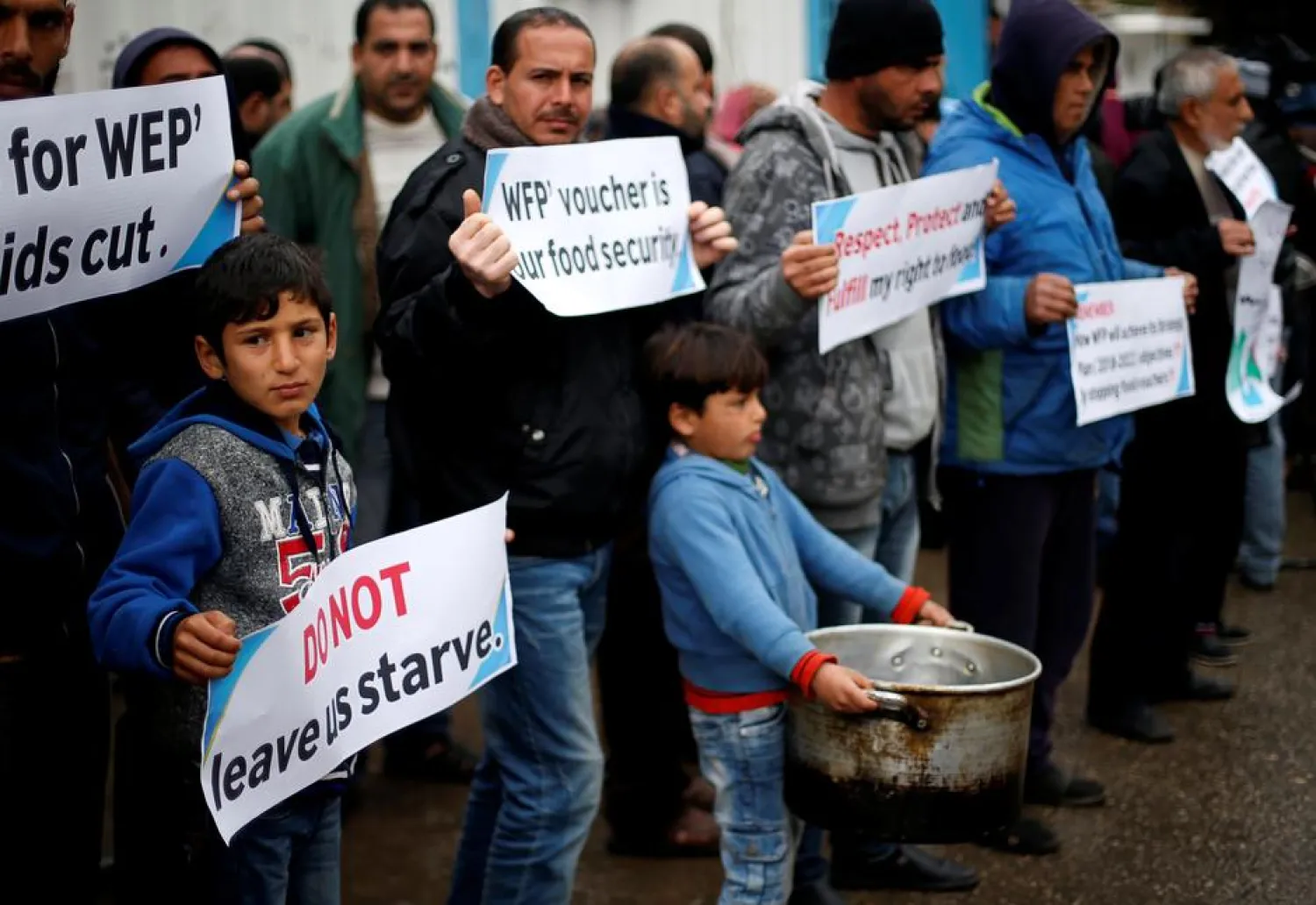 Palestinians hold signs during a protest against aid cuts, outside United Nations' offices in Gaza City January 17, 2018. (Reuters)