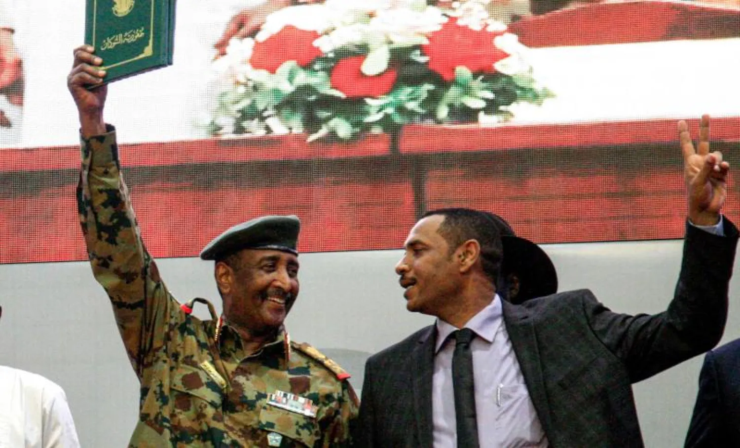 رئيس المجلس العسكري وممثل «قوى الحرية والتغيير» بعد التوقيع على وثيقة المرحلة الانتقالية (أ.ف.ب)