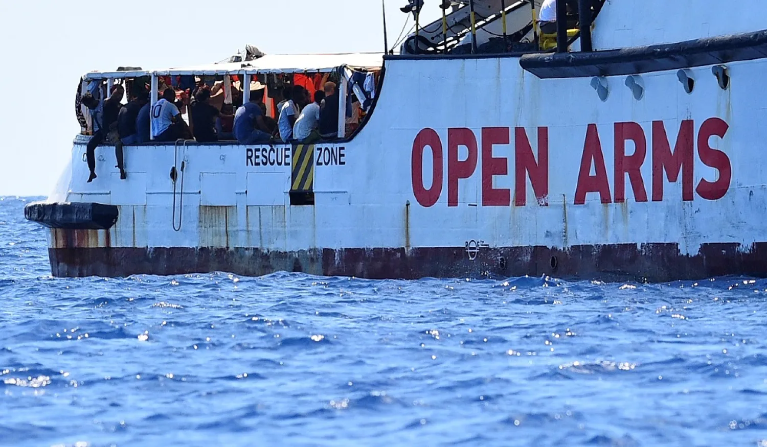 Migrants are seen aboard the Spanish migrant rescue ship Open Arms, close to the Italian shore at Lampedusa. (Reuters)