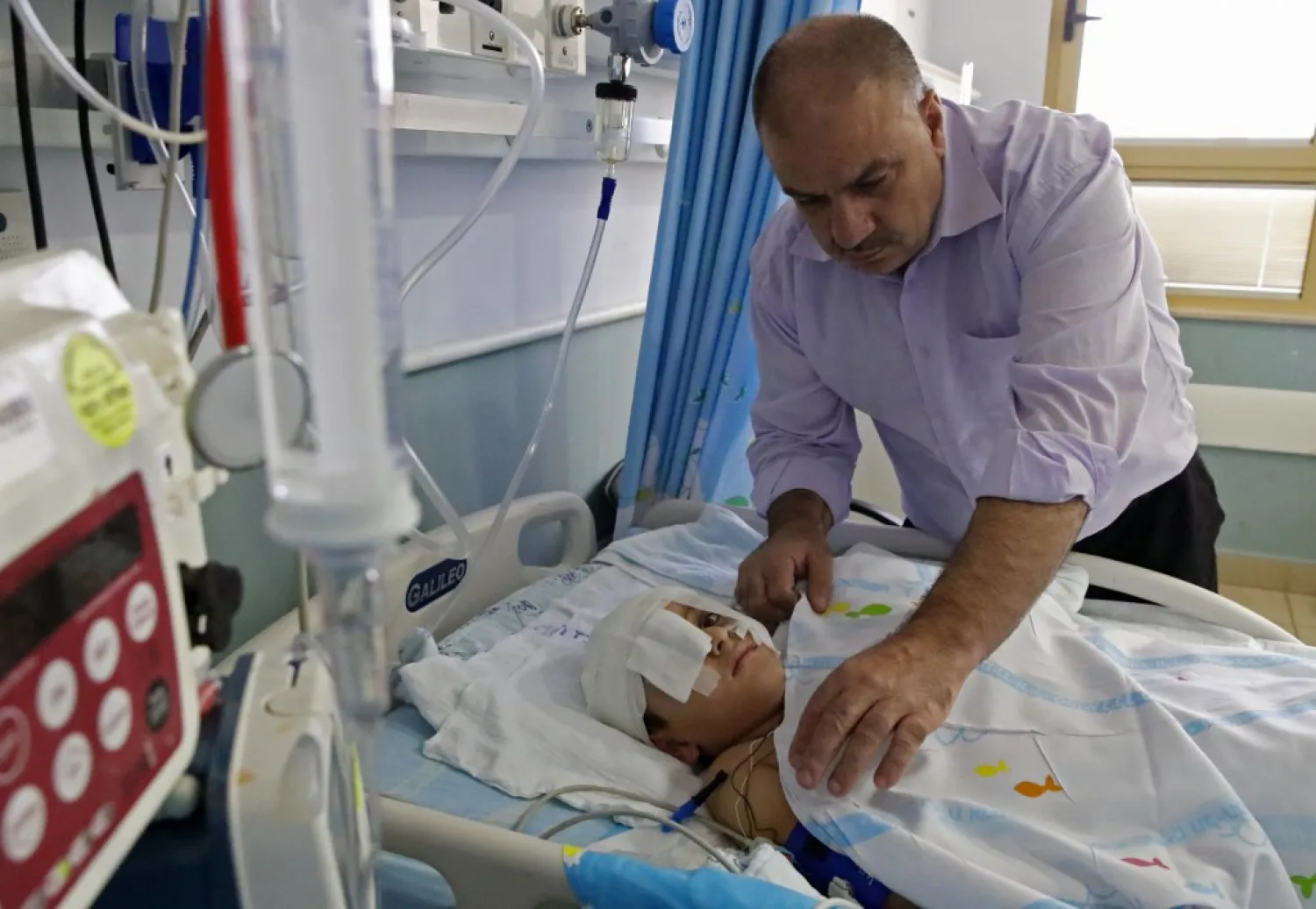 Yassir Shtewi sleeps each night by his son's bed in an Israeli hospital | AFP