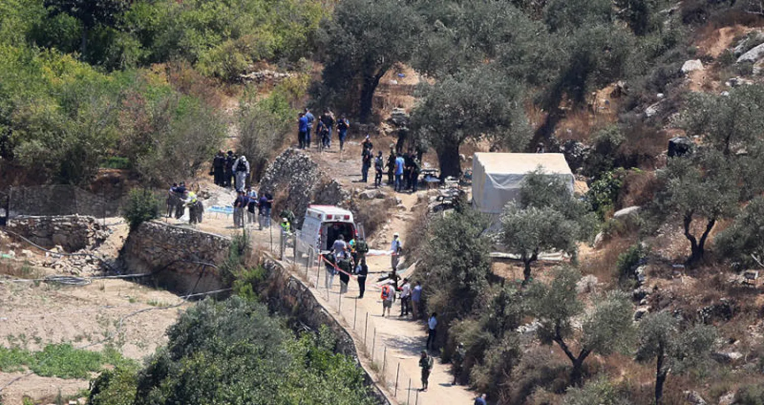 جنود ومسعفون خلال نقل جثة المستوطنة التي قُتلت بتفجير عبوة في الضفة الغربية أمس (إ.ب.أ)