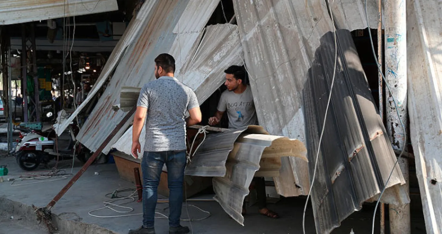 أصحاب محال تجارية يعاينون أمس الأضرار التي خلفها تفجير في المسيب جنوب بغداد الليلة قبل الماضية (أ.ب)