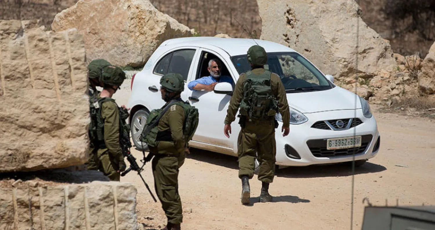 قوات الأمن الإسرائيلية تفتش السيارات غرب رام الله أمس (أ.ب)