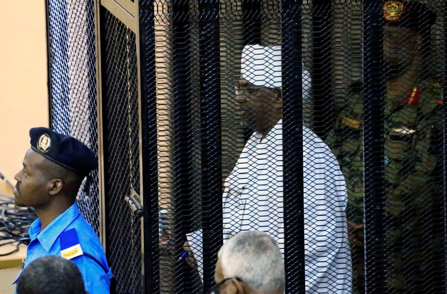 Sudan's former president Omar Hassan al-Bashir stands guarded inside a cage at the courthouse where he is facing corruption charges, in Khartoum, Sudan August 19, 2019. (Reuters)
