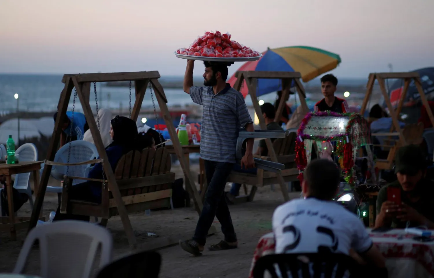 A vendor sells candied apples on the beach in Gaza City July 2, 2019. REUTERS/Mohammed Salem