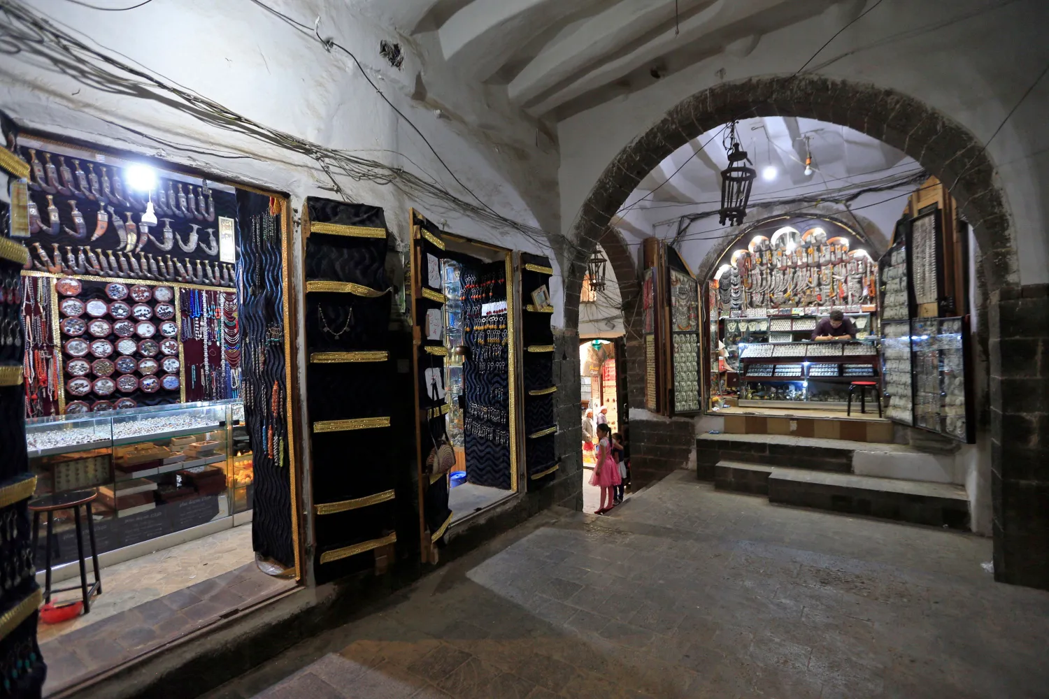 أصحاب متاجر بانتظار الزبائن في سوق مدينة صنعاء القديمة (أ.ف.ب)