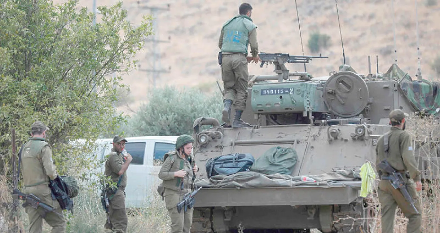 جنود إسرائيليون قرب دبابتهم عند الحدود مع لبنان أمس (أ.ف.ب)