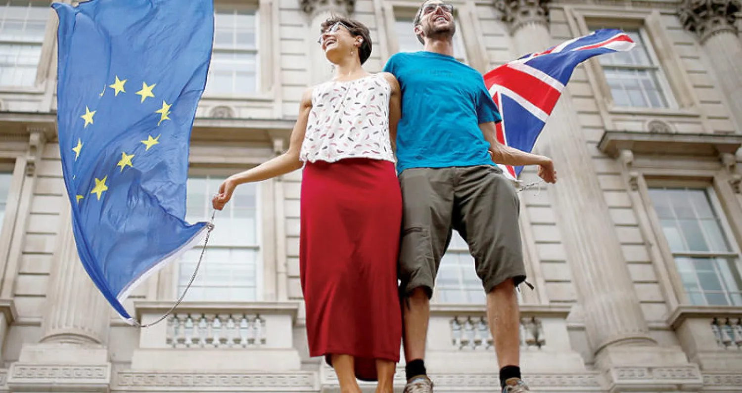 متظاهران يحملان علم بريطانيا وعلم الاتحاد الأوروبي خلال مظاهرة في العاصمة لندن أمس (رويترز)