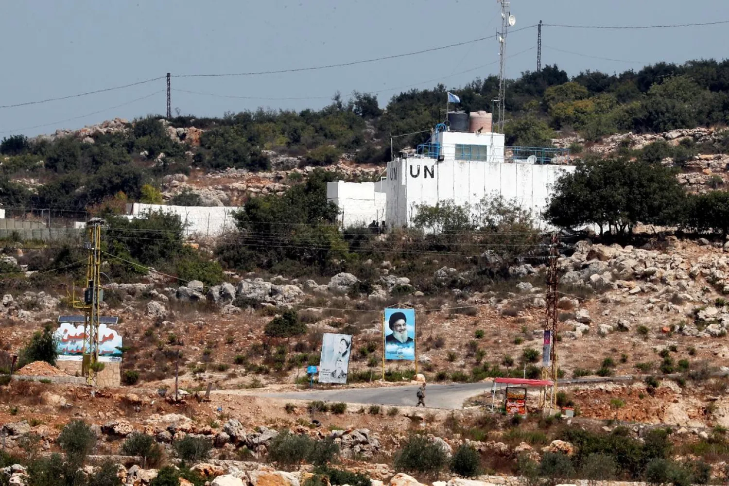 A banner depicting Hezbollah leader Hassan Nasrallah and a UN post are seen in Lebanon from the Israeli side of the border, near Zar'it in northern Israel August 28, 2019. (Reuters)