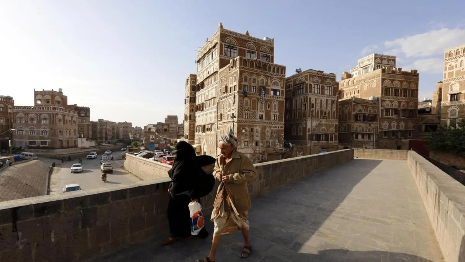 Yemenis walk past historical buildings in Sanaa, Yemen. (EPA)