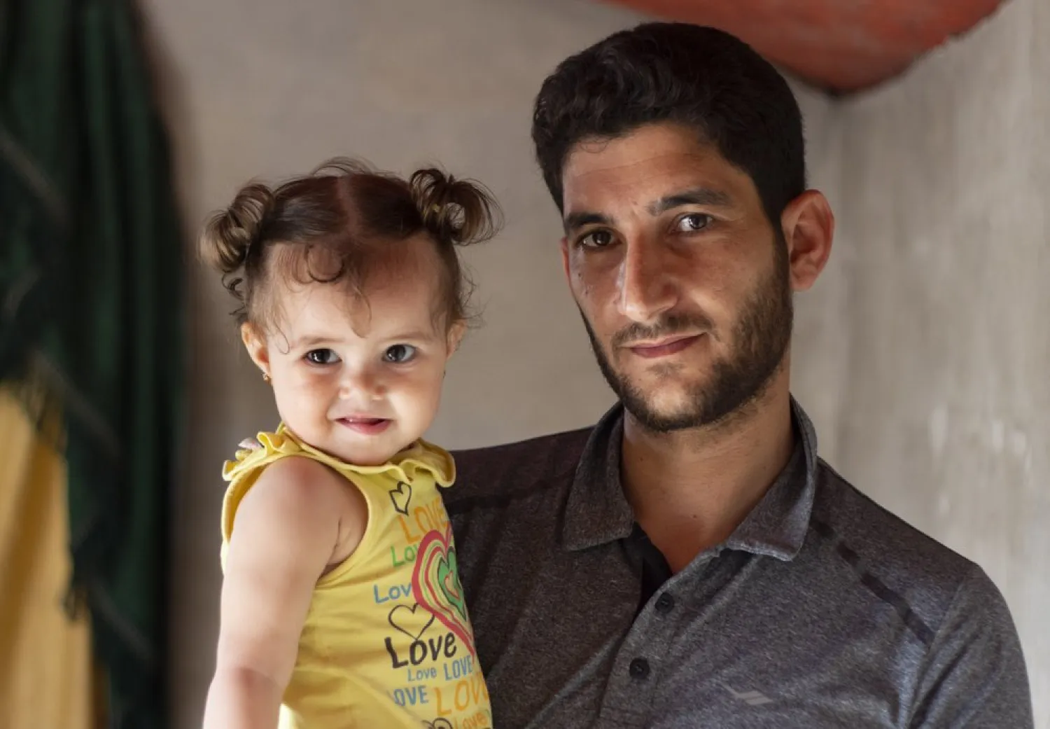 In this Sunday September 1, 2019 photo, Abdel Hamid al-Yousef poses for a picture with his 11-month-old daughter Aya, at a displaced settlement near the Turkish border called "Mokhayyam al-Karamah," Arabic for "Dignity Camp," near the town of Atmeh, in northern Syria. Al-Yousef lost his baby twins, his wife and 16 other relatives in the poison gas attack that hit Syria's Khan Sheikhoun in April 2017. Determined to continue with his life, he remarried, and has an 11-month-old daughter. But tragedy keeps chasing the 31-year-old former shopkeeper as he recently fled a government assault on Idlib and the nonstop bombardment of Khan Sheikhoun. (AP Photo)