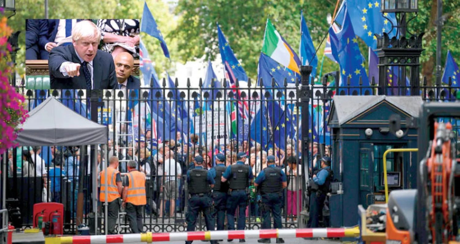 متظاهرون مناهضون لخروج بريطانيا من الاتحاد الأوروبي تظاهروا أمام بوابات مقر الحكومة في لندن أمس  وفي الإطار جونسون يتحدث خلال جلسة صاخبة في مجلس العموم فقد خلالها الأغلبية البرلمانية أمس (أ.ف.ب)