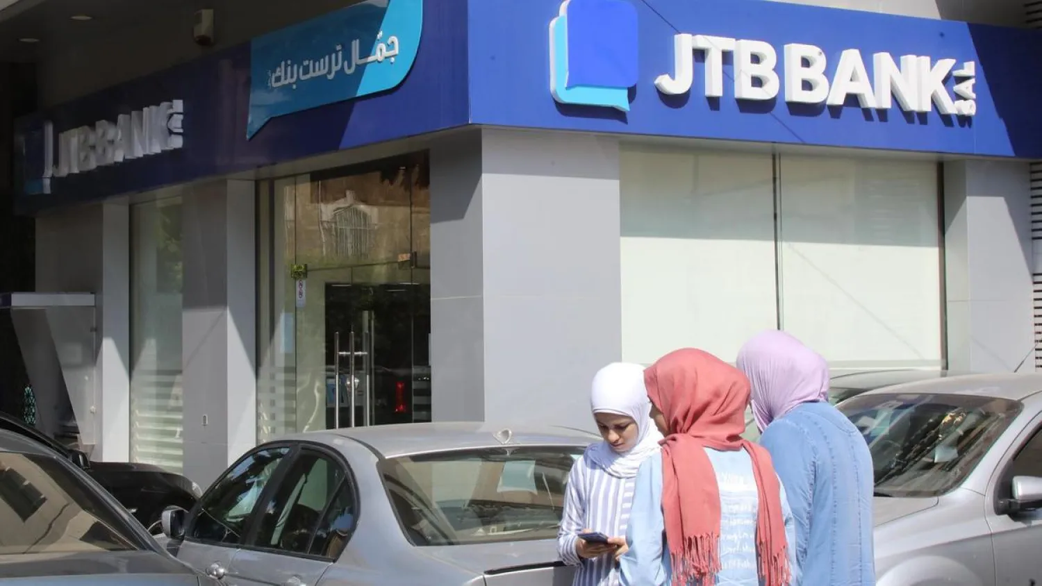 People walk past a branch of Jammal Trust Bank in the Beirut's Hamra street on August 30, 2019. (AFP)