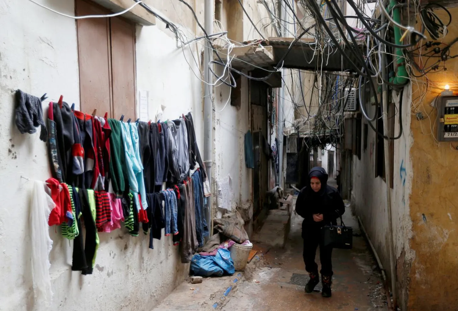 A woman walks past clothes left to dry in Burj al-Barajneh refugee camp in Beirut, Lebanon, January 29, 2018. Picture taken January 29, 2018. REUTERS/Mohamed Azakir
