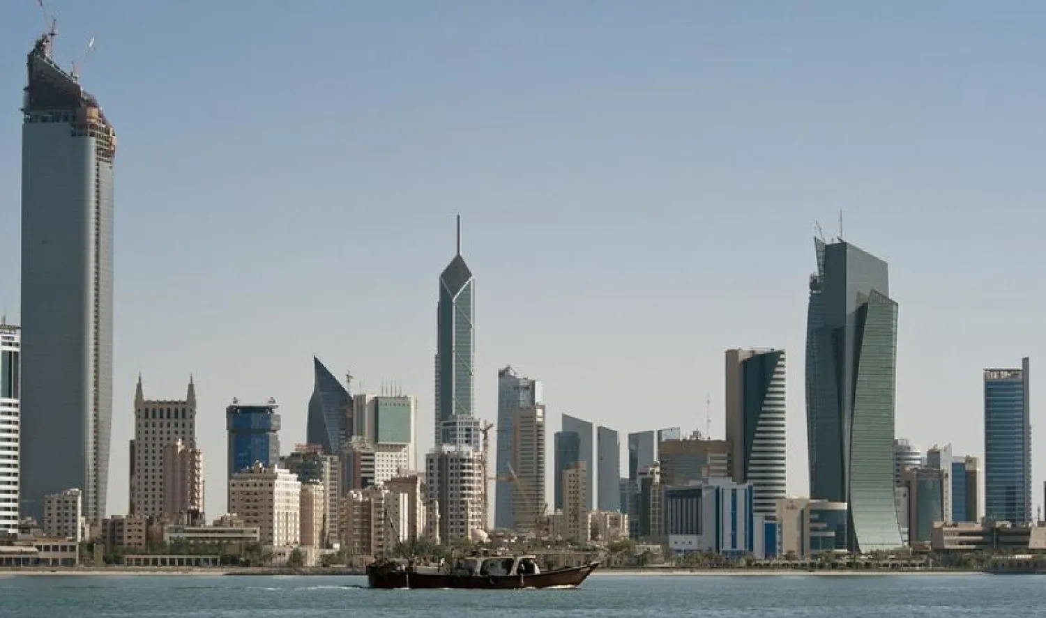 FILE PHOTO: A fishing boat passes in front of the Kuwait City skyline September 11, 2010. REUTERS/Stephanie McGehee

 