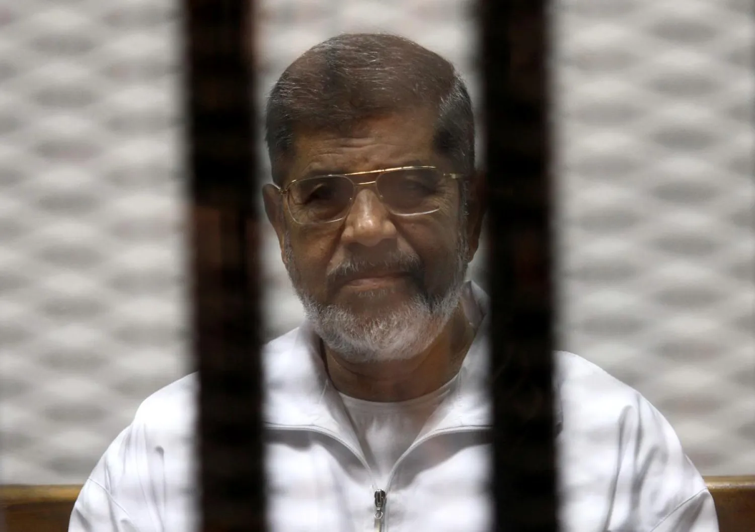 FILE PHOTO: Ousted Egyptian President Mohamed Morsi is seen behind bars during his trial at a court in Cairo May 8, 2014. REUTERS/Stringer/File Photo 