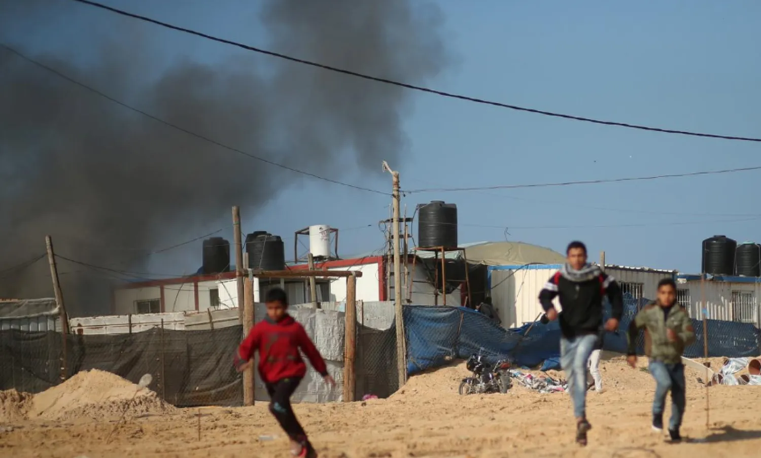 Palestinians run as smoke rises following what police said was an Israeli air strike on a Hamas post, in the northern Gaza Strip February 6, 2017. REUTERS/Mohammed Salem