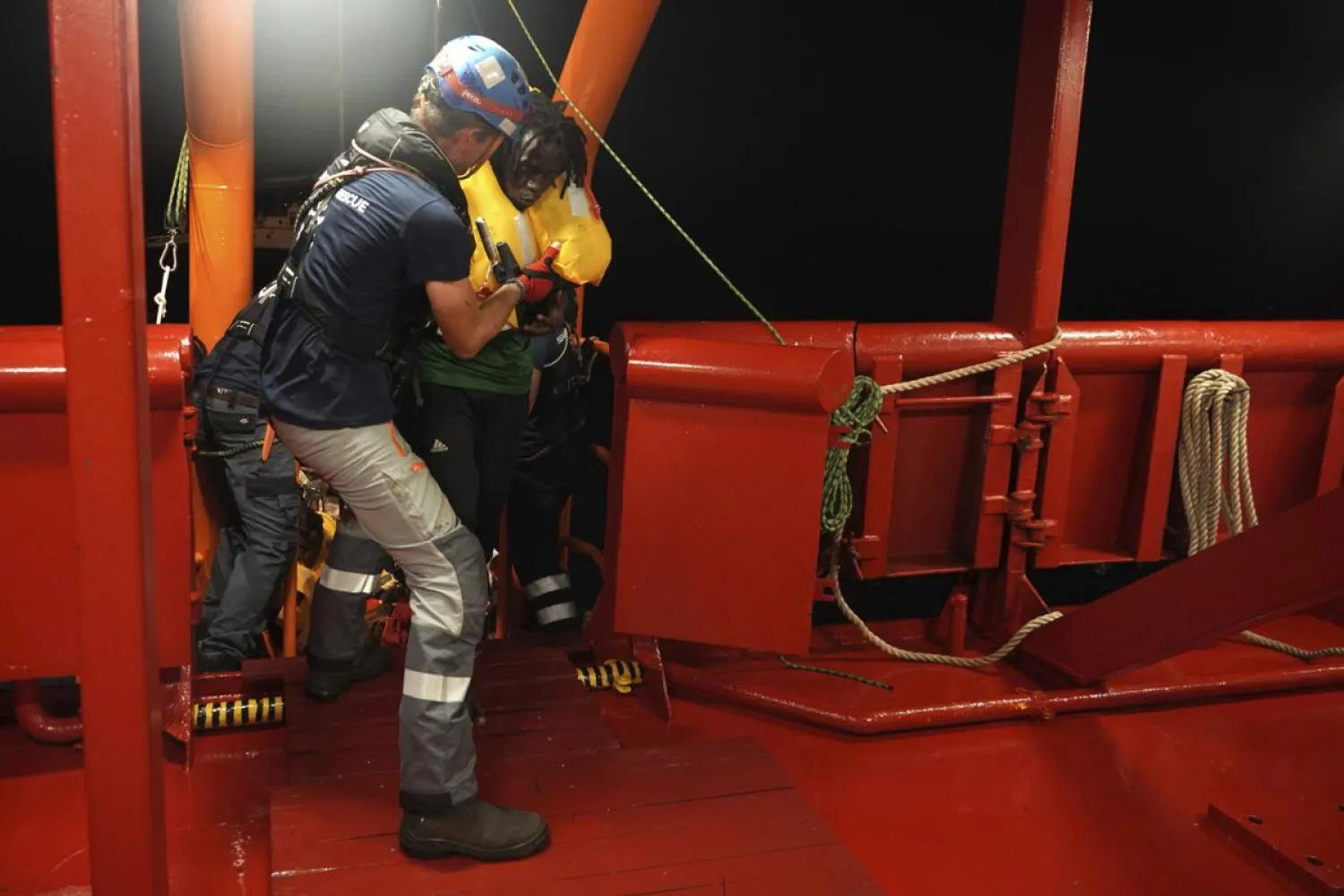 A rescued migrant is helped aboard the humanitarian ship Ocean Viking after being rescued at sea by a 14-meter sailboat Josefa, run by the group Resqship, in the Mediterranean Sea, late Monday, Sept. 9, 2019. Thirty-four migrants including women and the small child who were rescued by the German sailboat have been successfully taken aboard the humanitarian ship in international waters north of Libya despite a thunderstorm. (AP Photo/Renata Brito)