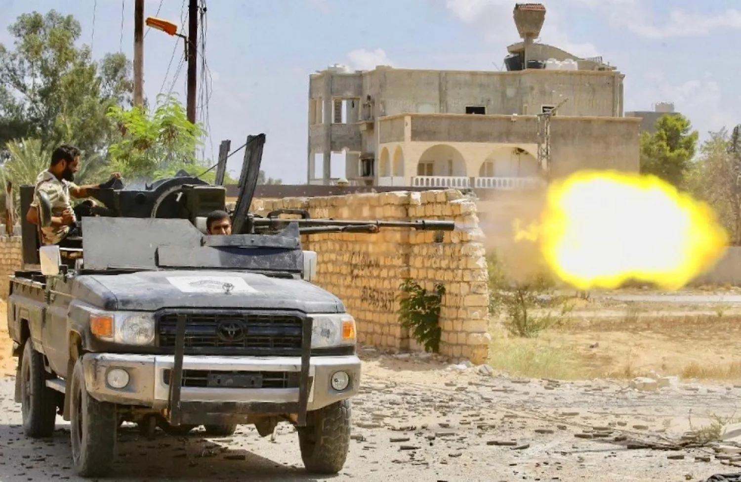 A GNA fighter fires a truck-mounted gun during clashes with LNA forces in a suburb of the capital Tripoli. (AFP)