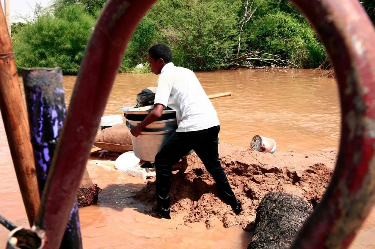 A Sudanese man carries his belongings in Wad Ramli village on the eastern banks of the Nile river. (AFP)