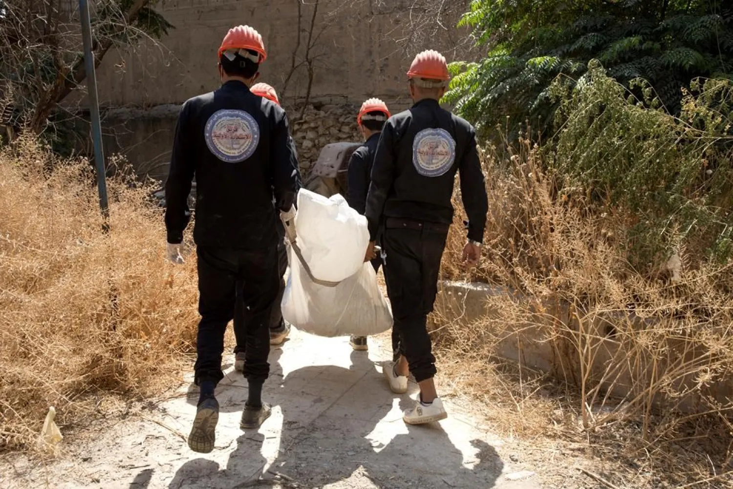 In this Saturday, Sept. 7, 2019 photo, first responders remove a body at the site of a mass grave in Raqqa, Syria. (AP Photo/Maya Alleruzzo)