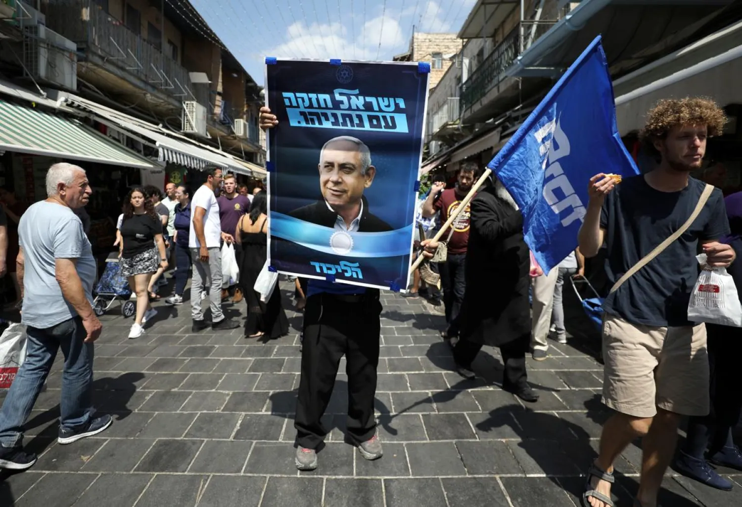 A supporter of the Likud party holds an election campaign poster depicting Israeli Prime Minister Benjamin Netanyahu in Jerusalem, September 13, 2019. (Reuters)