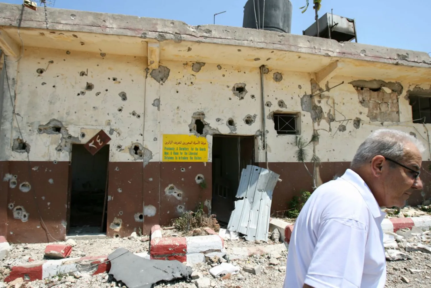 This August 16, 2006 file photo, a Lebanese man walks past the damaged former Israeli Khiam prison, in the southern town of Khiam, Lebanon, that was attacked during the July 2006 war. (AP)